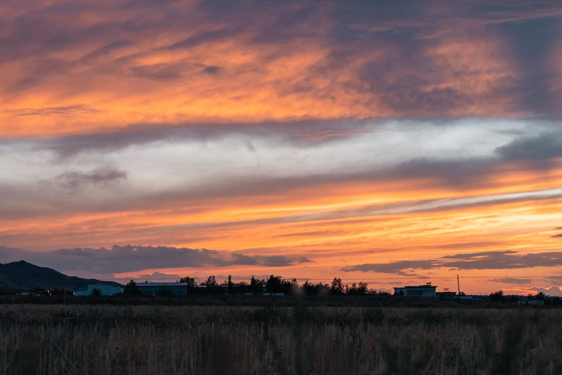 A sunset sky over a rural landscape