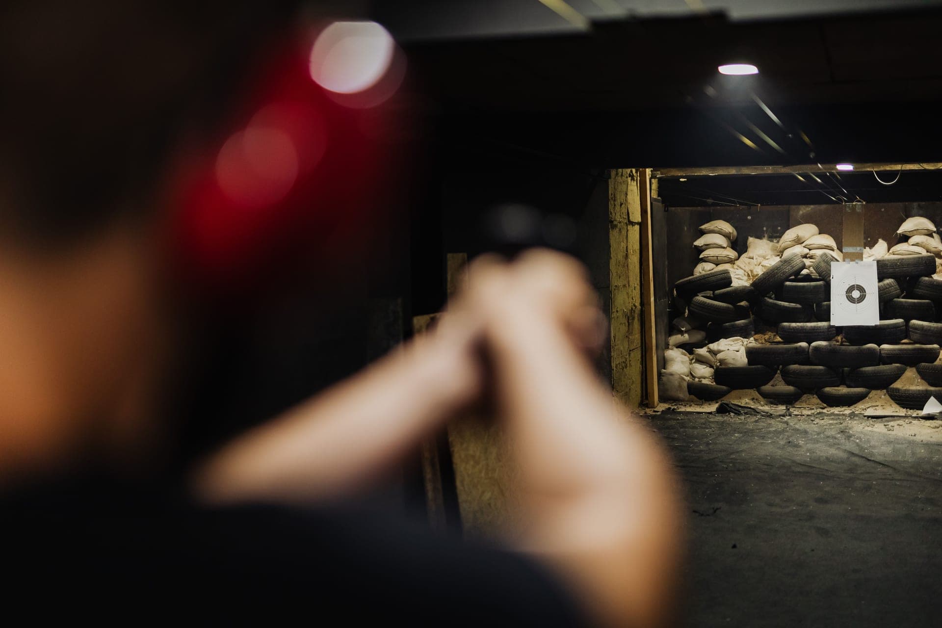 A person aiming at a target on an indoor shooting range